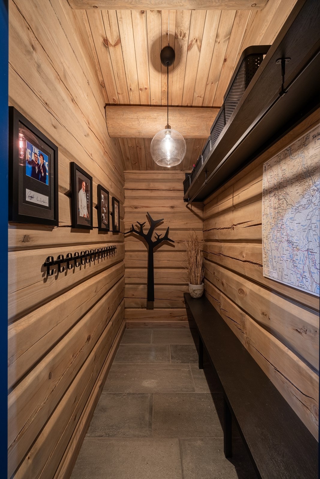 Klærne henges bort i et stort garderobeskap med sorte skuffer og dører i profilert utførelse. Galleribilde