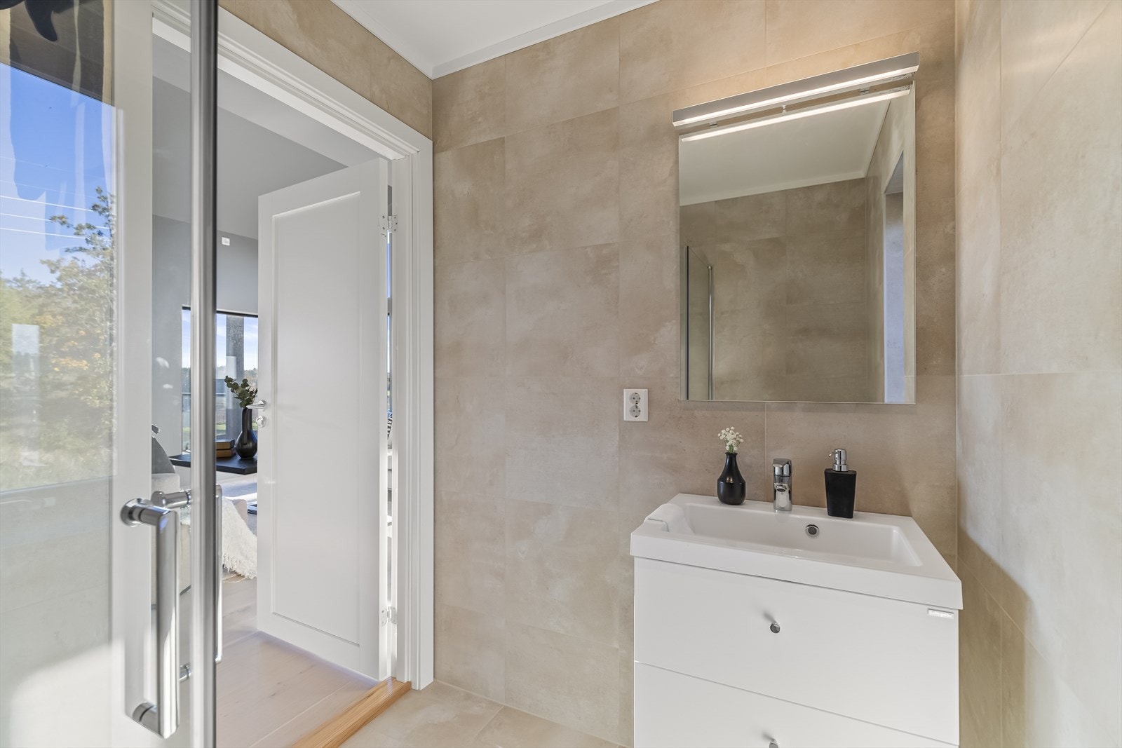 Dusjinnredningen har innfellbare dører av glass og dusjgarnityr med regnfallsdusj. Videre er det vegghengt toalett, lys baderomsinnredning med skuffer og nedfelt servant, samt speil og integrert belysning. Galleribilde