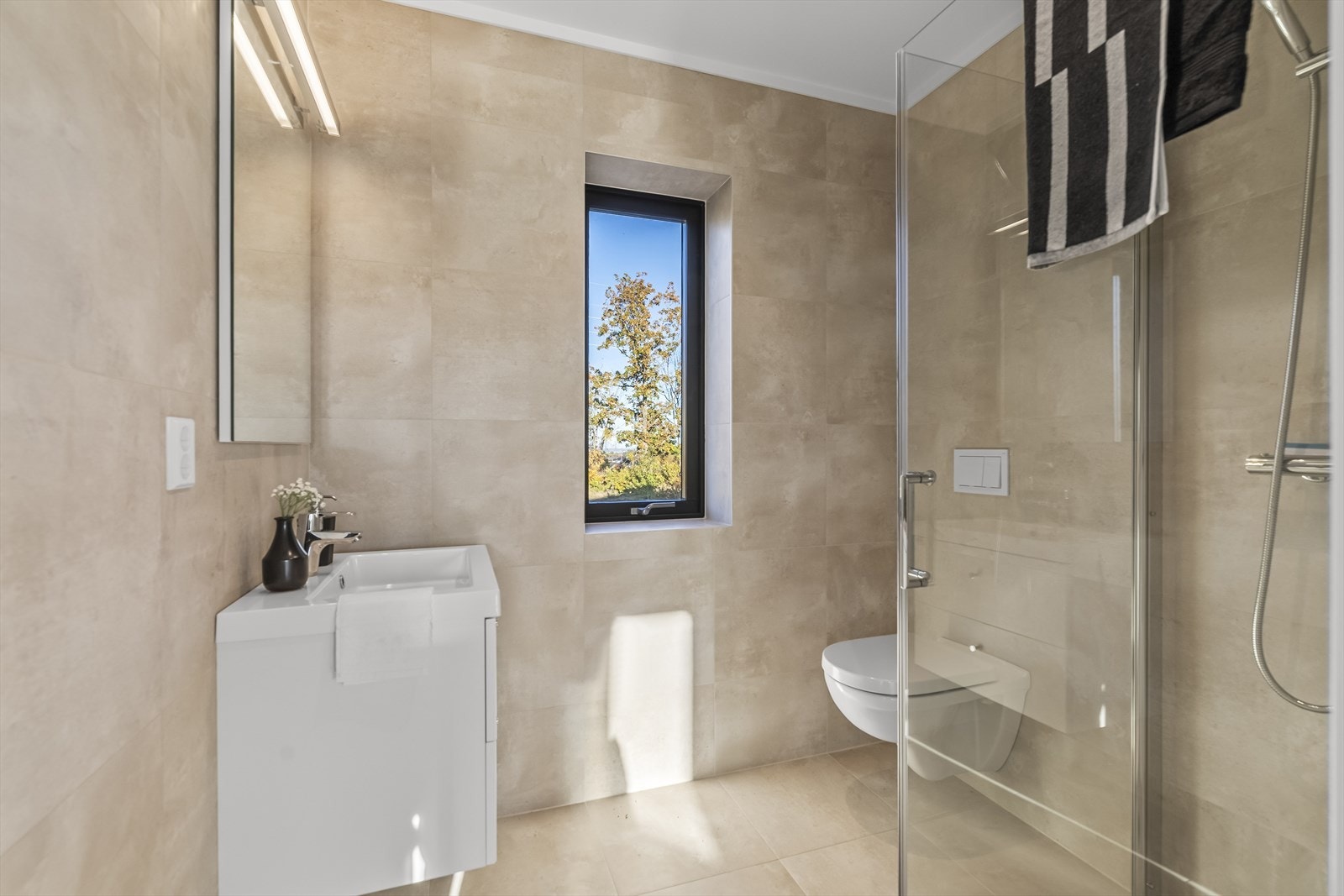 Badet er særdeles innbydende og delikat med flislagte overflater og moderne innredning. Galleribilde