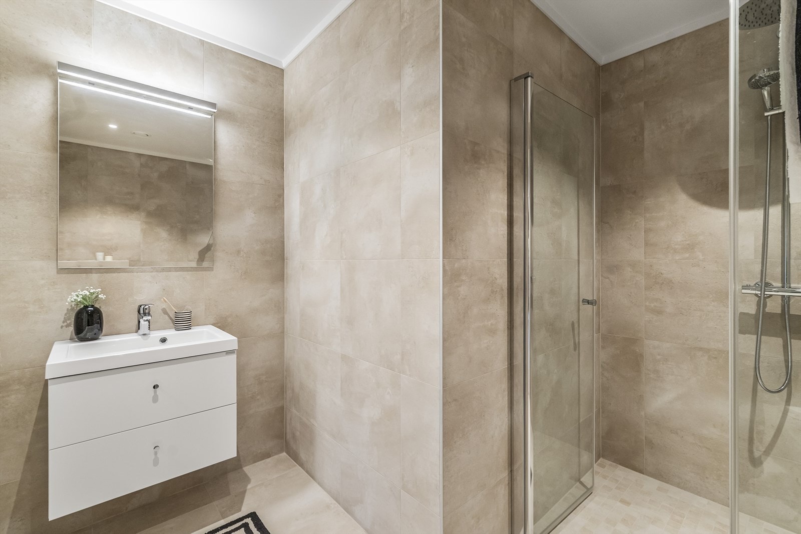 Badet i denne etasjen er særdeles delikat med flislagte overflater og innredning i elegant stil. Galleribilde