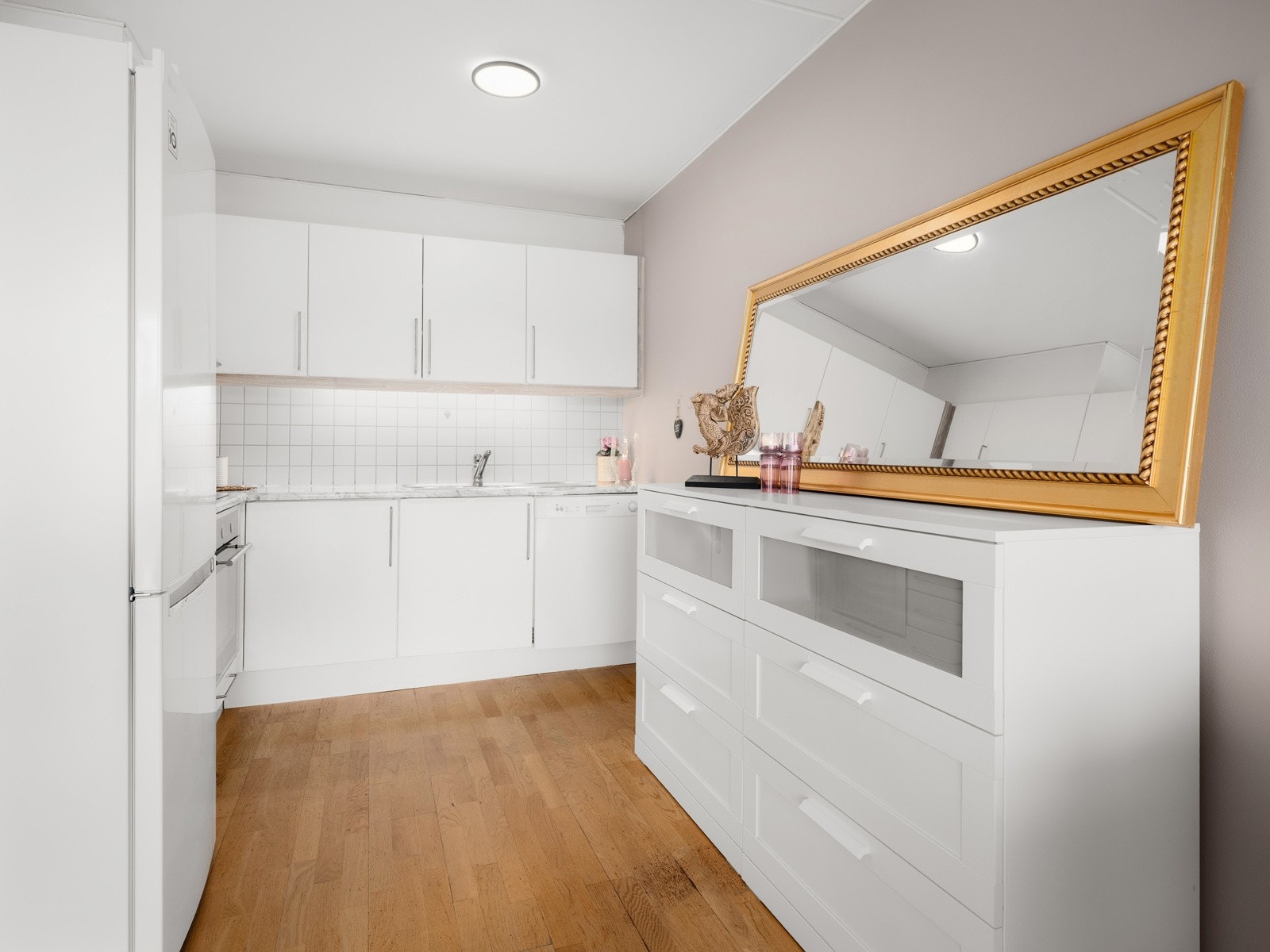 Tidløst kjøkken med lyse, glatte fronter og benkeplate av laminat. Galleribilde