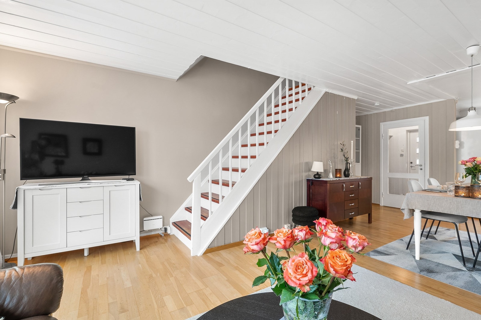 Stuen har laminatgulv, kombinasjon av veggpaneler, slette vegger og paneler i himling Galleribilde