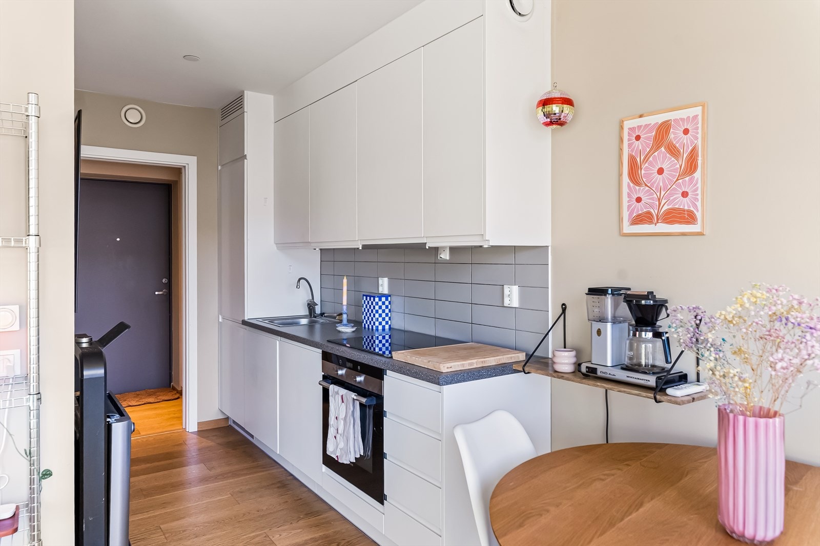 Kjøkkenet har et tidløst og delikat design med hvite, glatte fronter og en praktisk benkeplate i laminat. Galleribilde