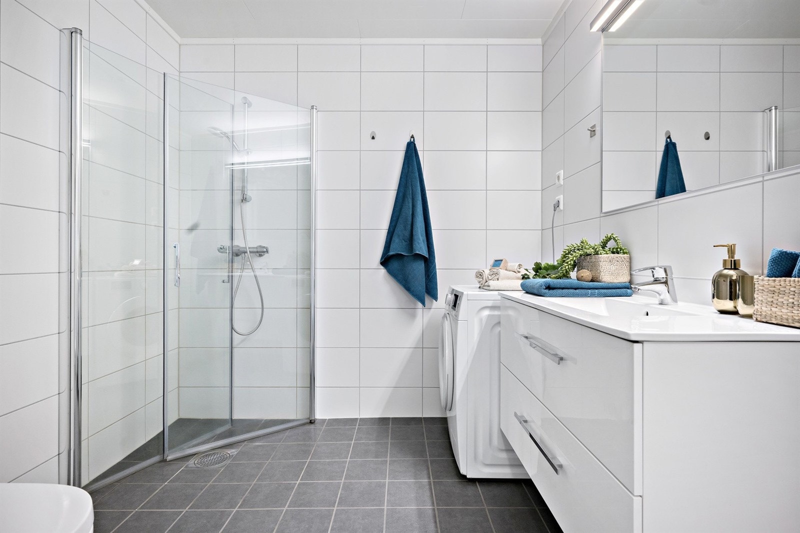 Lekkert, flislagt bad med varme i gulv. Dusjnisje, wc, servant og opplegg til vaskemaskin. Galleribilde