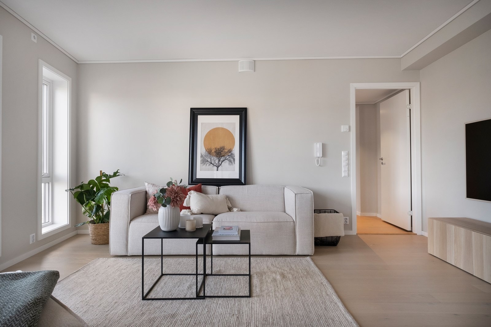 Lys og tiltalende stue med åpen kjøkkenløsning, utsikt og utgang til balkong via skyvedør Galleribilde