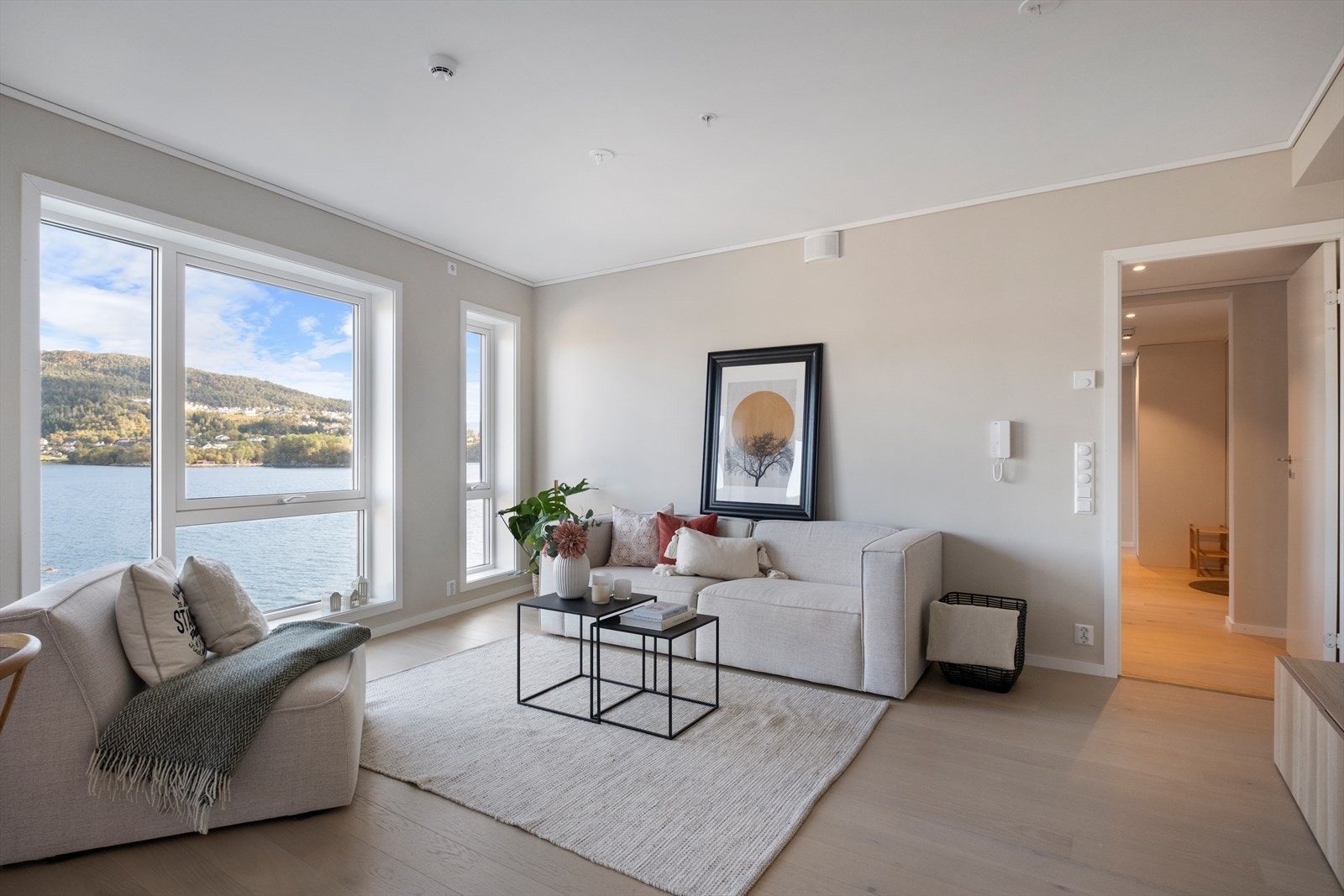 Lys og tiltalende stue med åpen kjøkkenløsning, utsikt og utgang til balkong via skyvedør Galleribilde