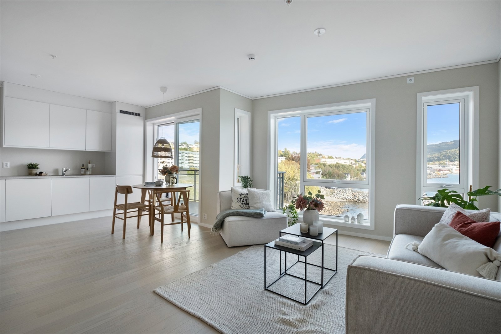 Romslig stue med utsikt og skyvedør til balkong Galleribilde