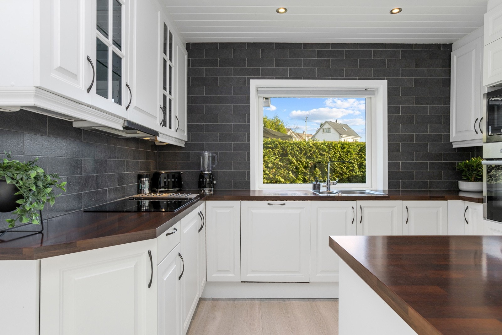 Hvit, profilert innredning og benkeplater i kontrastfarge. Galleribilde