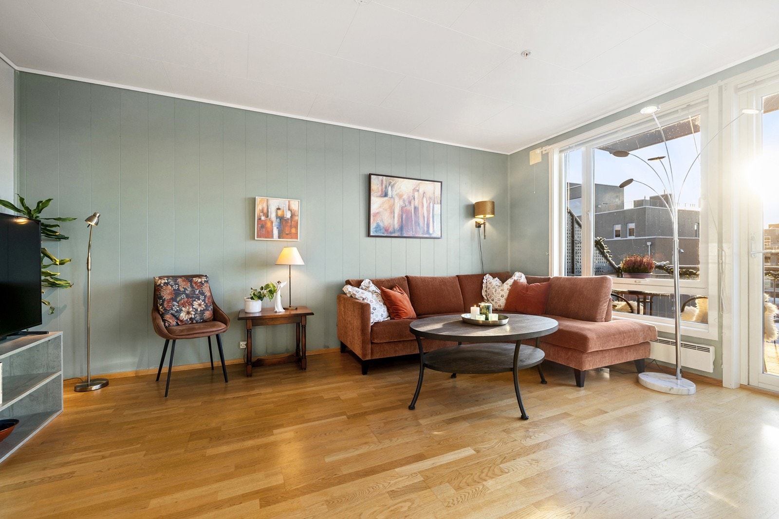 Stuen er malt i en moderne lysegrønn nyanse og det er parkett på gulvet. Galleribilde