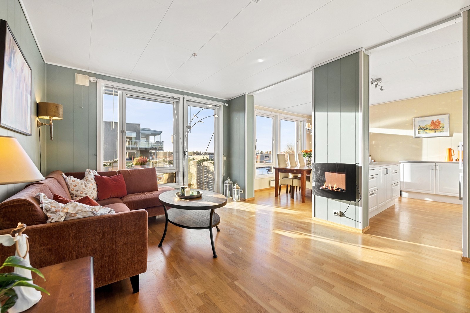 Lys og romslig stue med delvis åpen løsning mot kjøkken og spiseplass. Galleribilde