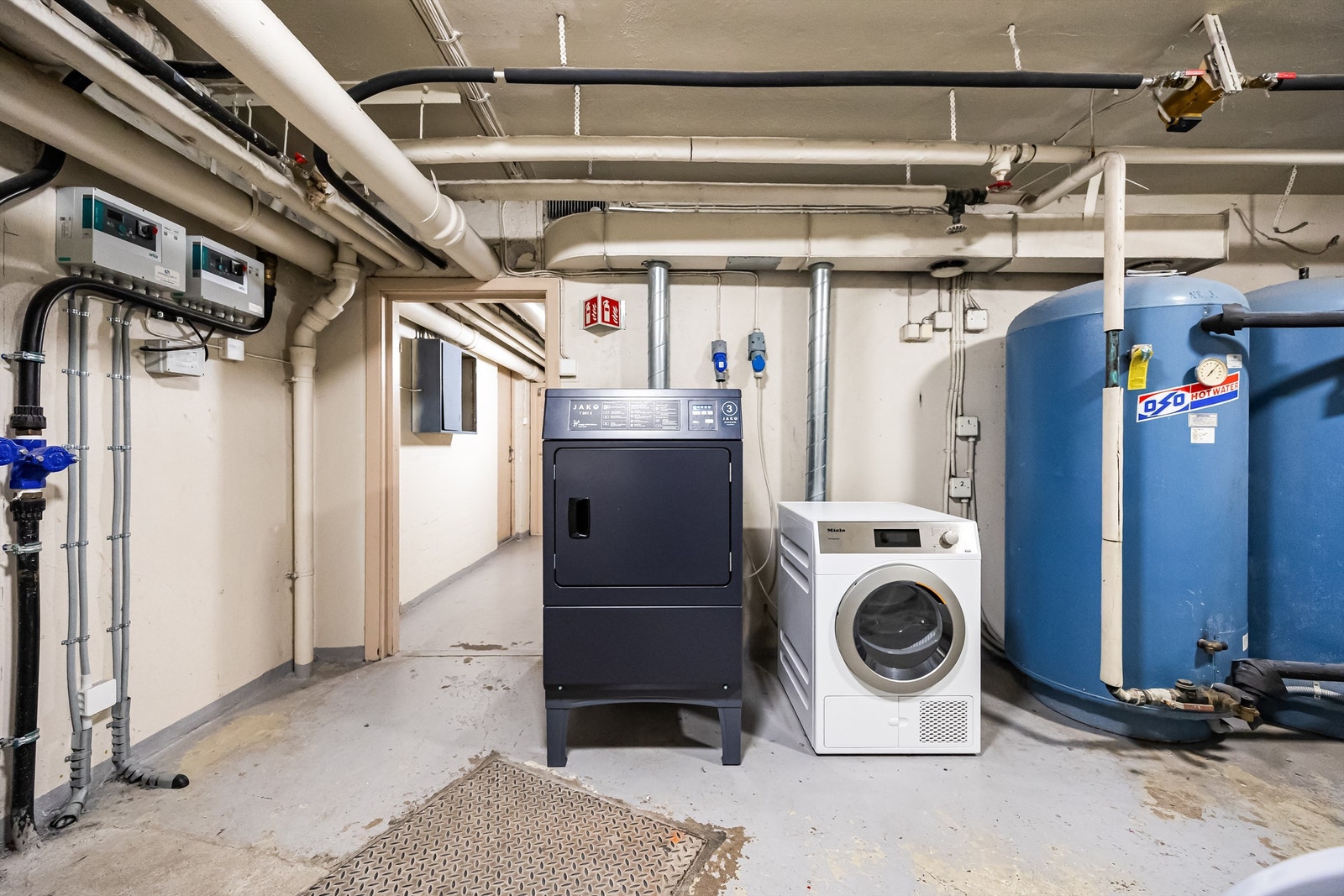 Felles og kostnadsfritt vaskeri utstyrt med to store industri vaskemaskiner og to tørketromler. Galleribilde