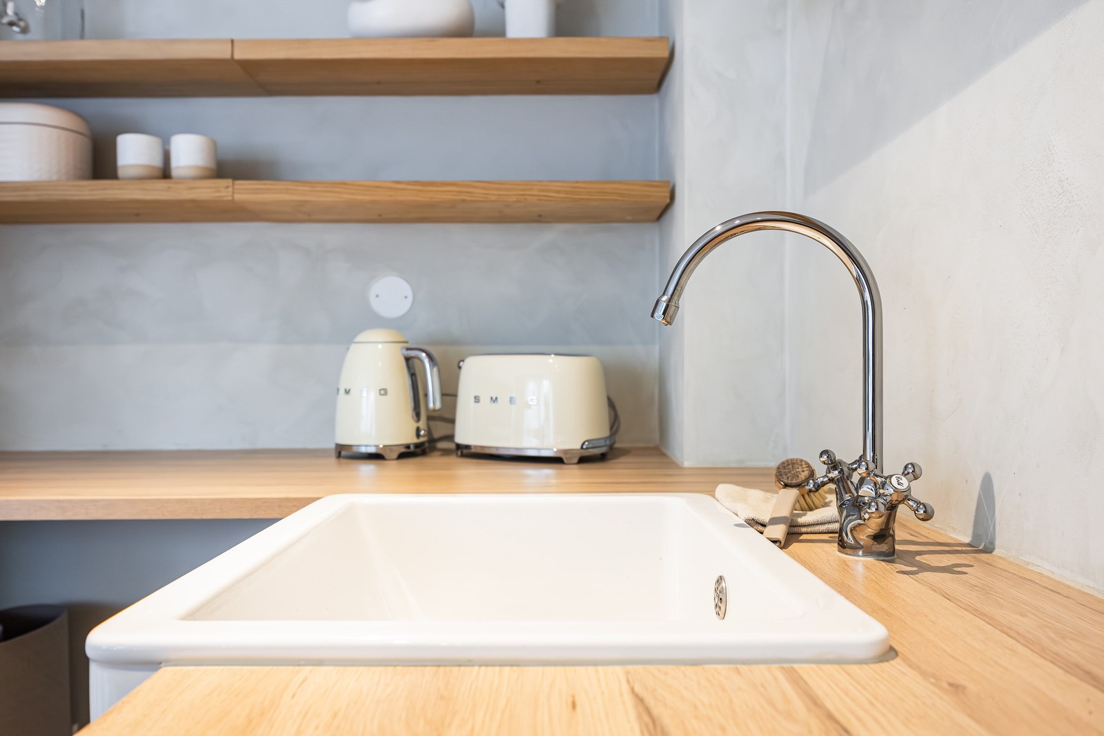 Nedfelt vaskekum av keramikk og retro detaljer på servant- et smykke i rommet. Galleribilde