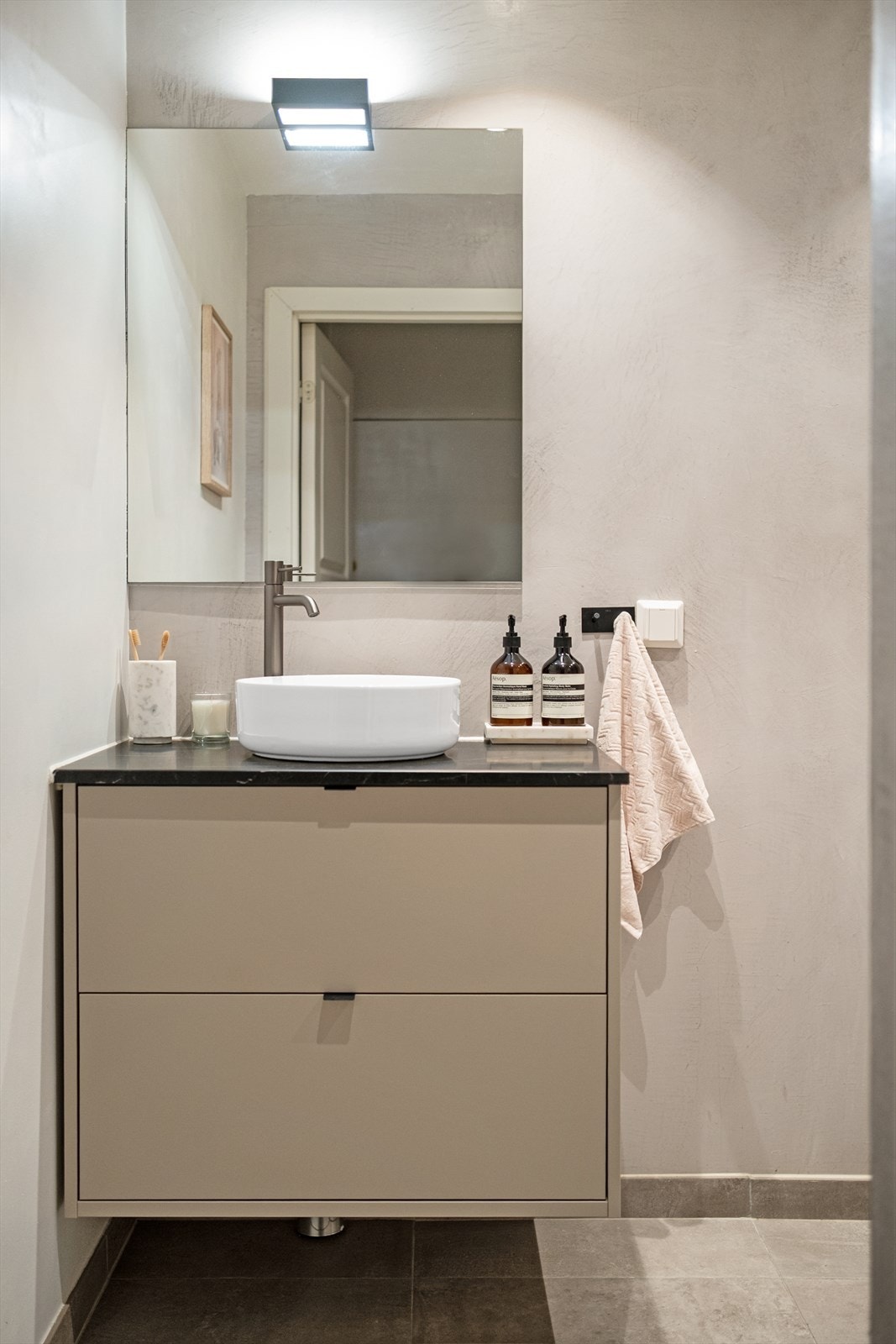 Baderommet er innredet med vegghengt klosett, servant på innredning og dusjhjørne med svingbare glassdører. Galleribilde