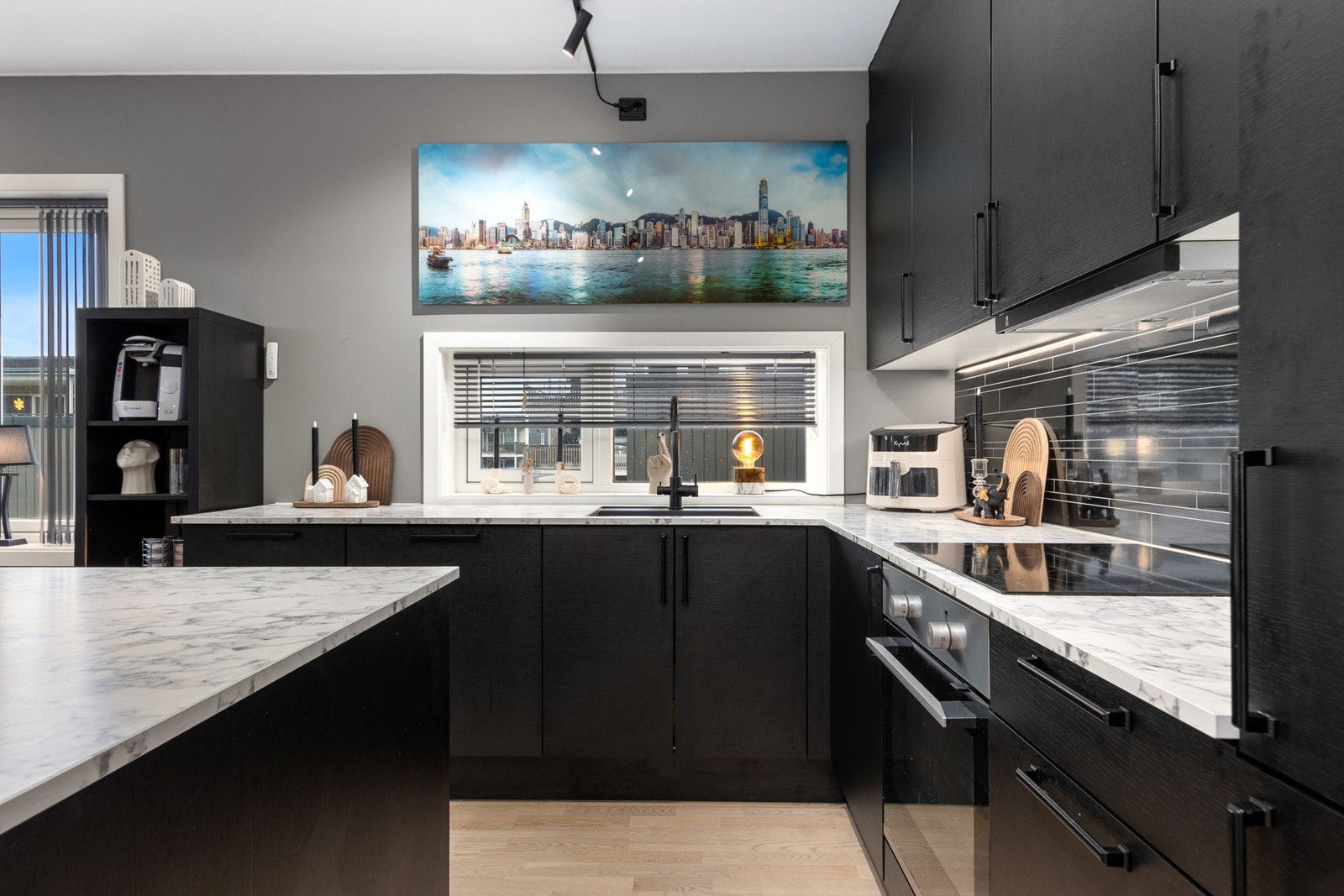 Kjøkken med integrerte hvitevarer og praktisk kjøkkenøy. Galleribilde