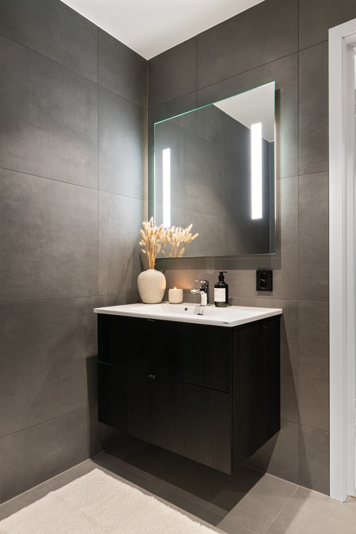 Bad i tilknytning til de to soverommene i 1. etasje. Alle baderommene er i samme utsøkte stil med store 60x60 fliser. Foto: Vidar Alvik Galleribilde