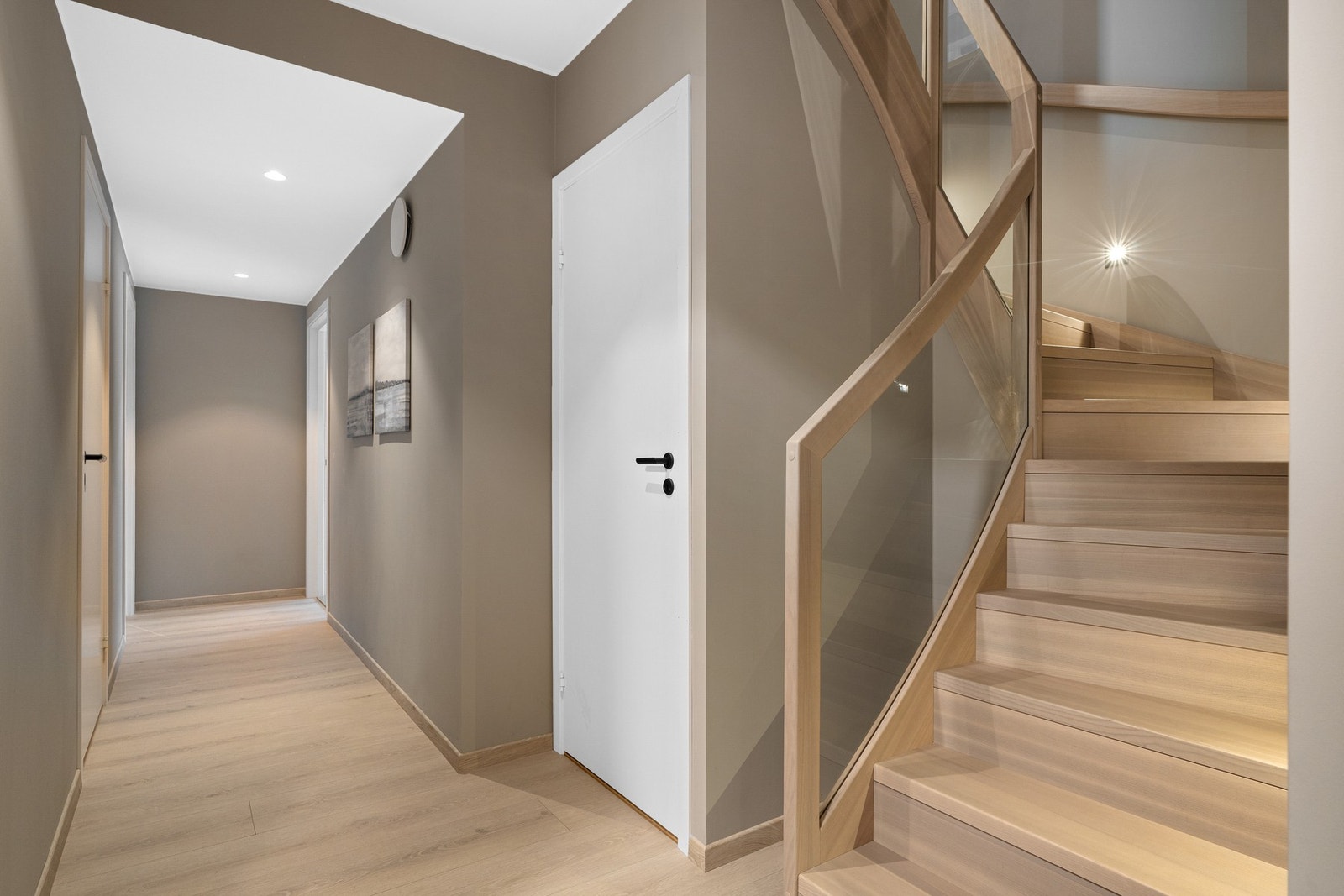 Trappen i ask er stilig og glir sømløst inn i interiøret, med innfelt belysning langs trinnene og rekkverk med glass. Foto: Vidar Alvik Galleribilde