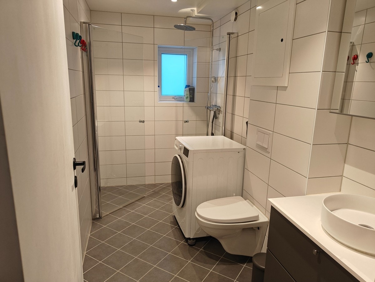 Flislagt bad med gulvvarme og vaskemaskin. Innredning av høy kvalitet. Galleribilde