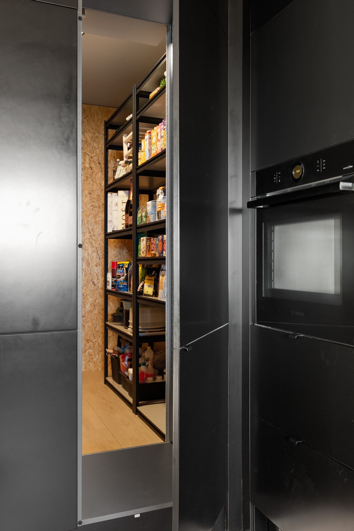 Meget praktisk matbod med skjult inngang integrert i kjøkkenet. Måler ca. 5,5 kvm, med ekstra benkeplass, stikkontakter og hylleoppbevaring. Galleribilde