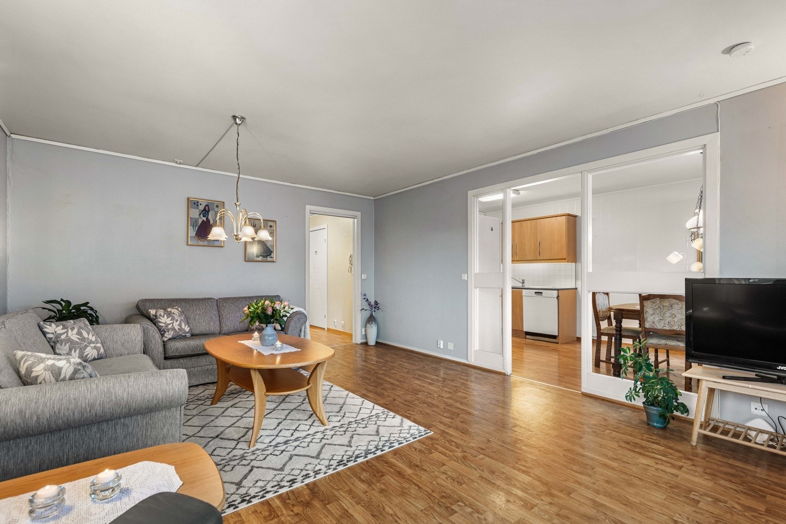 Lys og romslig stue med praktisk adkomst til både kjøkken og spiseplass. En funksjonell planløsning. Galleribilde