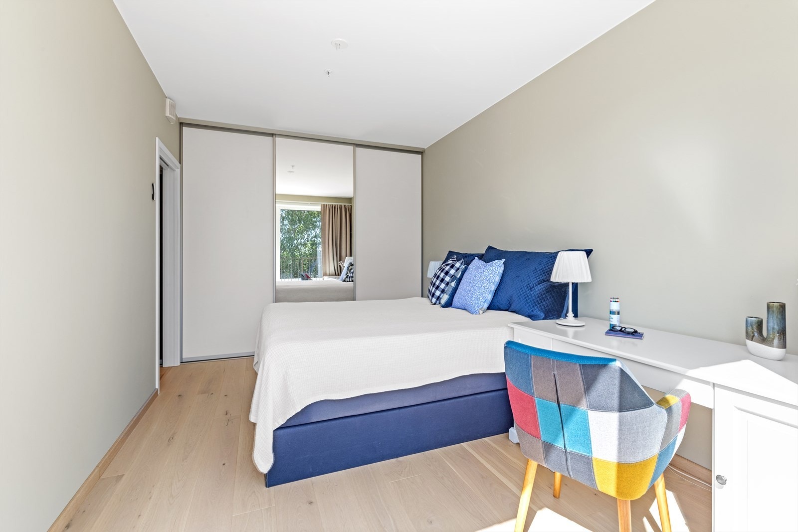 Det er montert en romslig garderobeløsning med skyvedører på soverommet Galleribilde