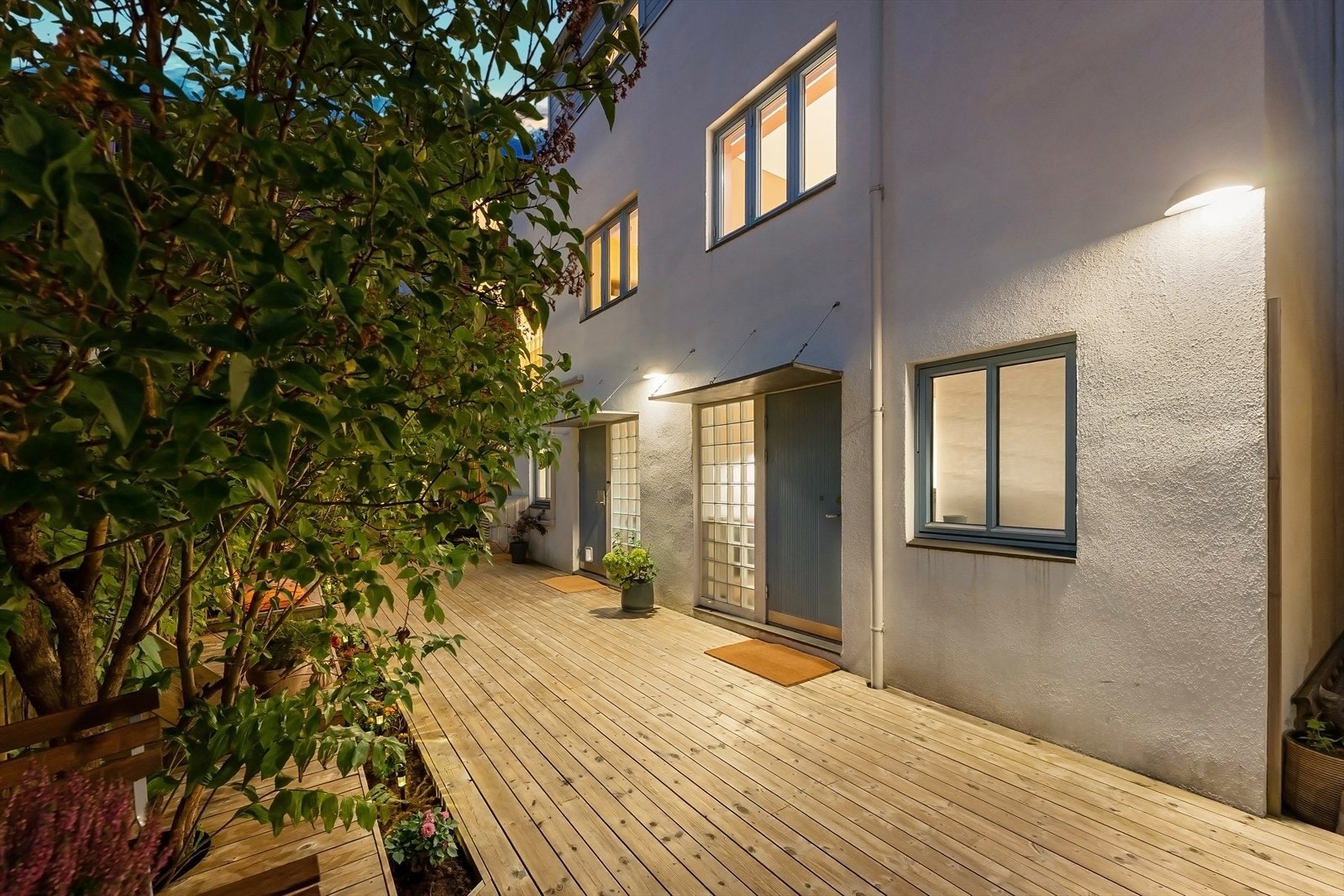 Eiendommen er svært pent opparbeidet med terrasseplatting på hele 55 kvm med snekkertilpassete sittebenker, blomsterkasser og flere møbleringssoner Galleribilde