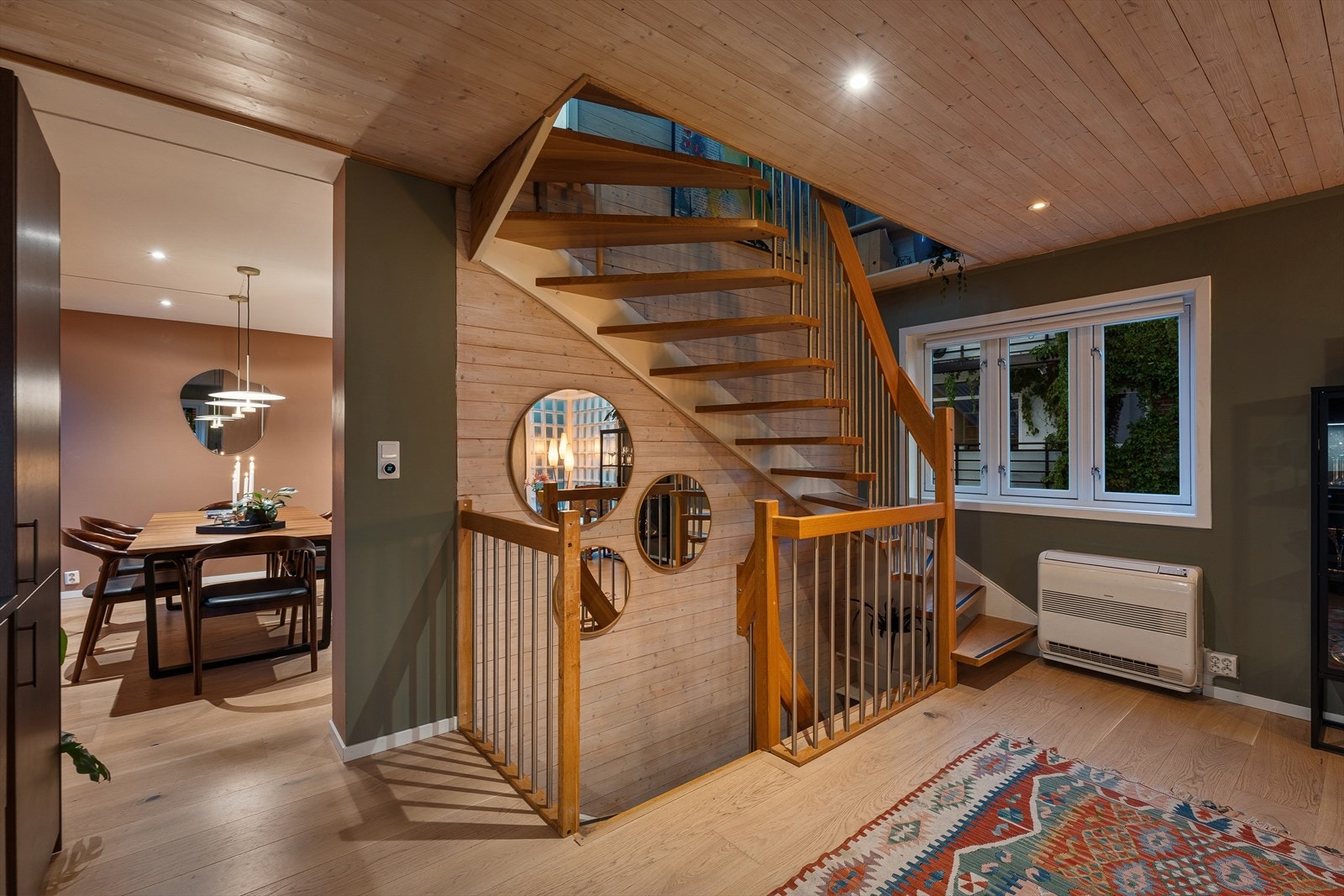 Funkisstil med elegant U-trapp og vinduer mot flere himmelretninger som gir godt med naturlig lys. Legg merke til varmepumpe Galleribilde
