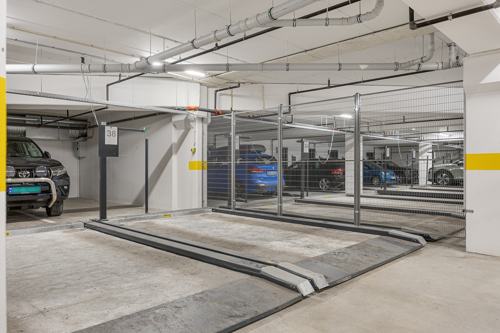 Det følger en parkeringsplass på automatisk parkeringssystem til leiligheten. Høyde i parkeringssystem er 205 cm. Maks billengde 510 cm. Bilens maksvekt er 2600 kg. Total plattformbredde 250 cm. Galleribilde