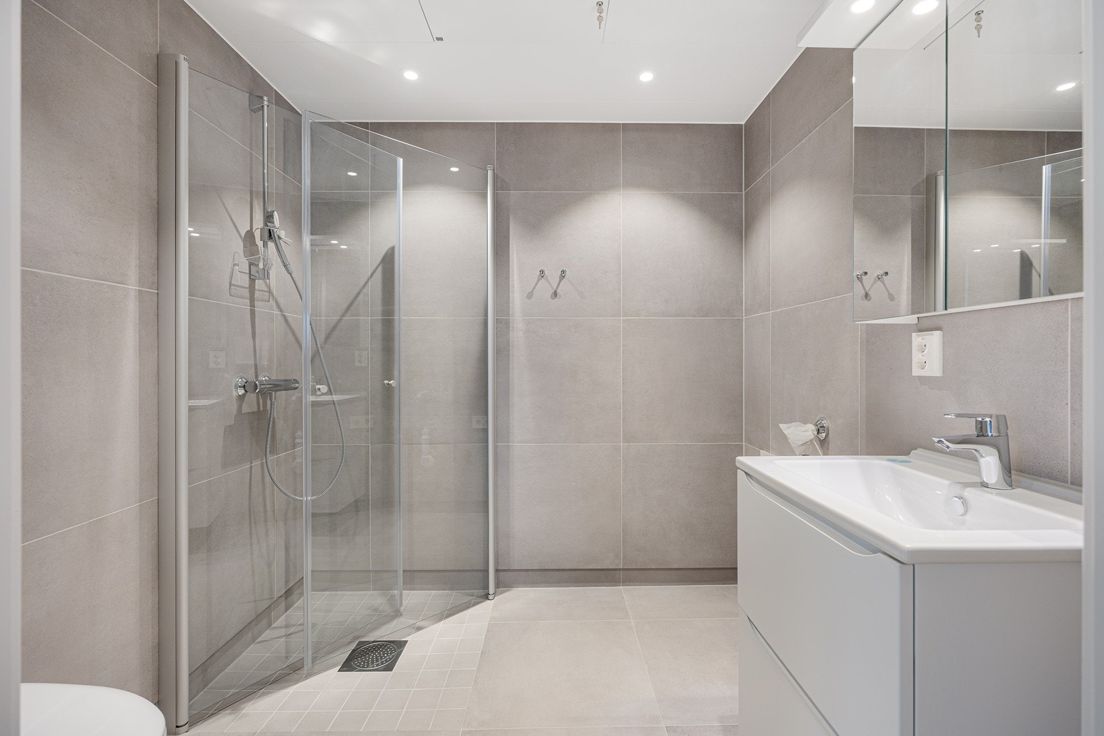 Baderommet er helfliset med store og stilrene fliser. Galleribilde