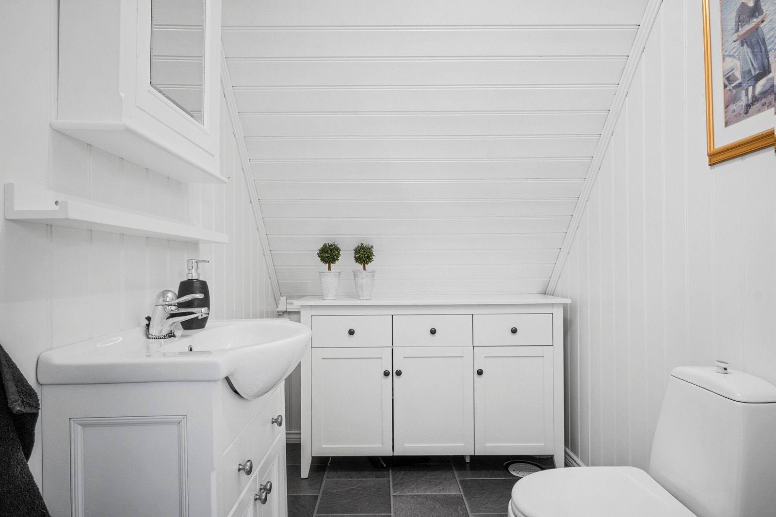 Toalettrommet er innredet med gulvfestet toalett, nedfelt servant med skapplass og speilskap. Galleribilde