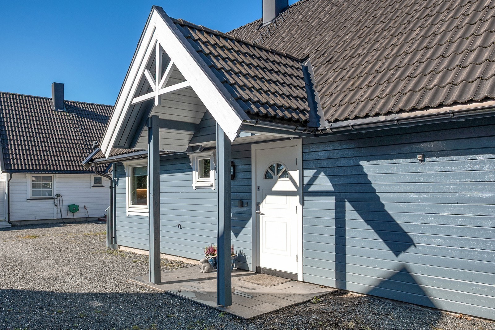 Fra gårdsplassen er det kort vei til boligens steinlagte og overbygde inngangsparti. Galleribilde