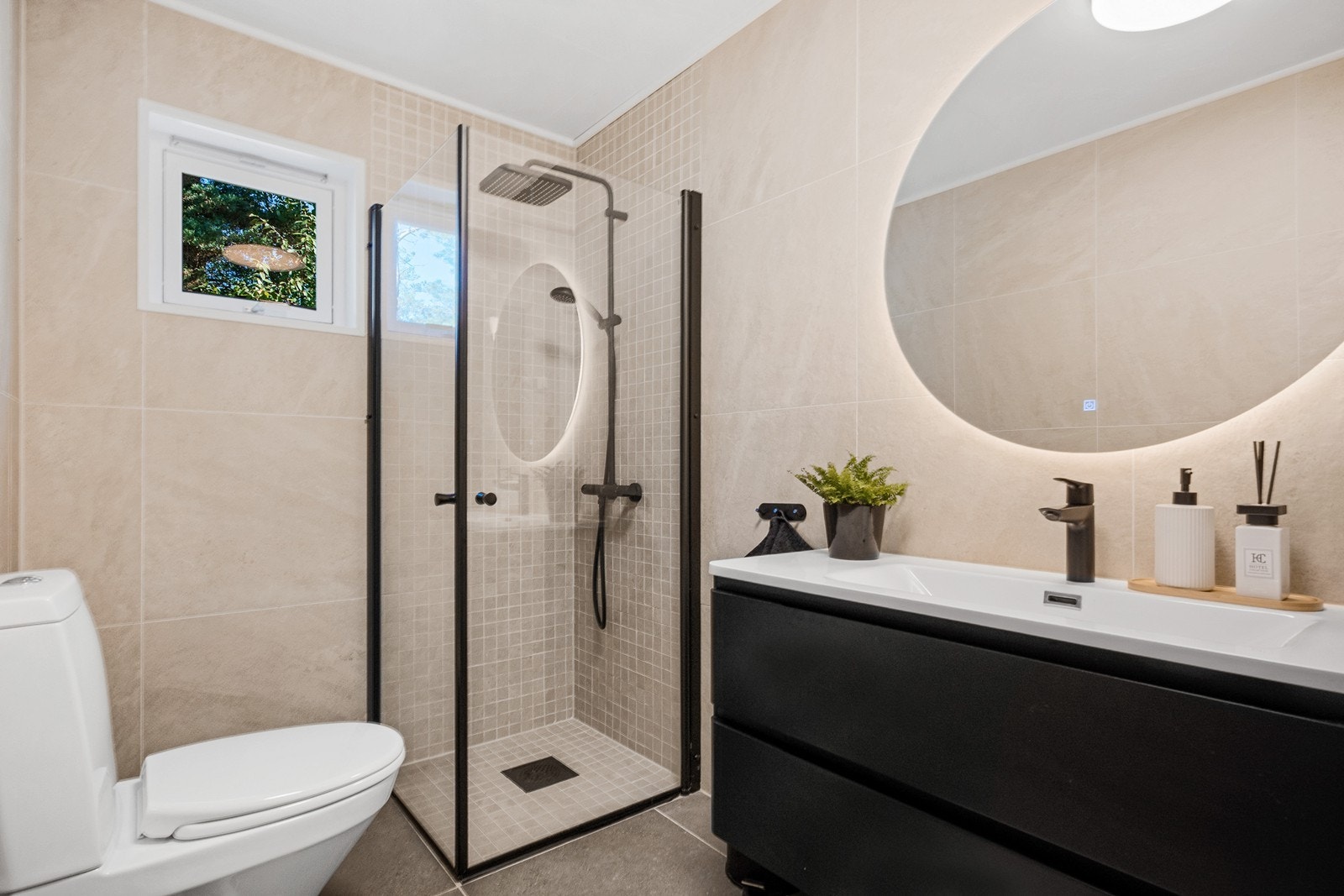 Dusjsonen er utstyrt med mosaikkfliser, tak- og hånddusj samt innfellbare glassvegger Galleribilde