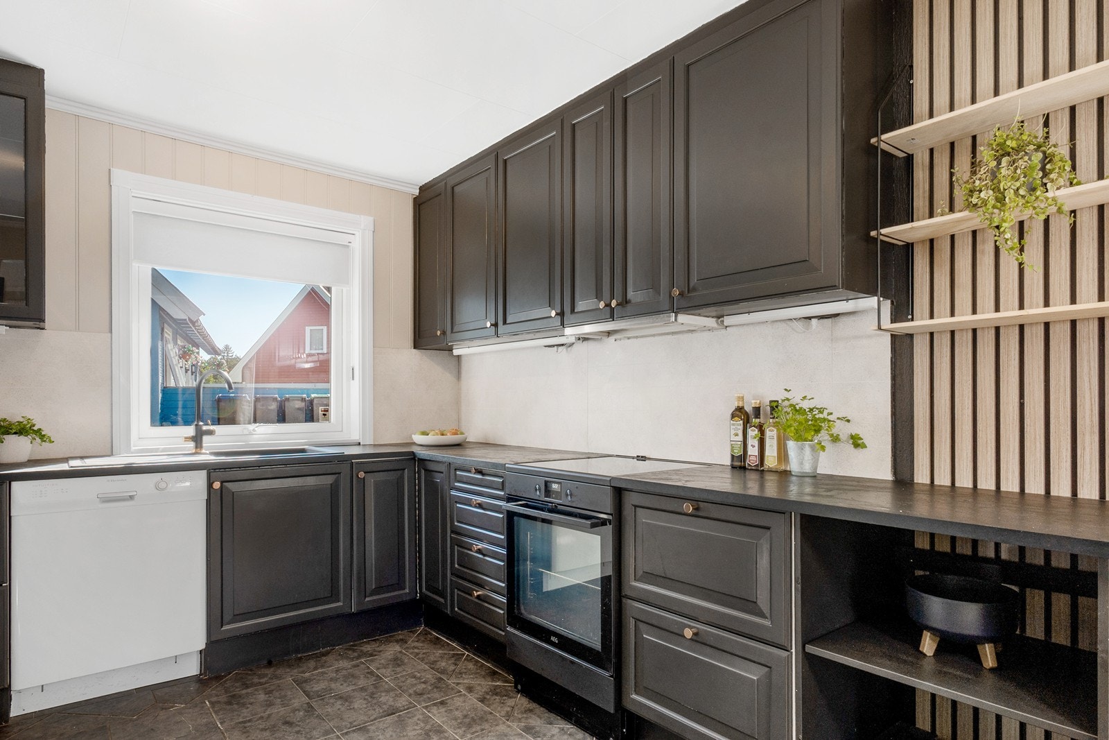 Kjøkkenet ligger i åpen løsning mot spisestuen og fremstår som både funksjonelt og stilrent. Rommet har flislagt gulv og detaljer med spilevegg. Galleribilde