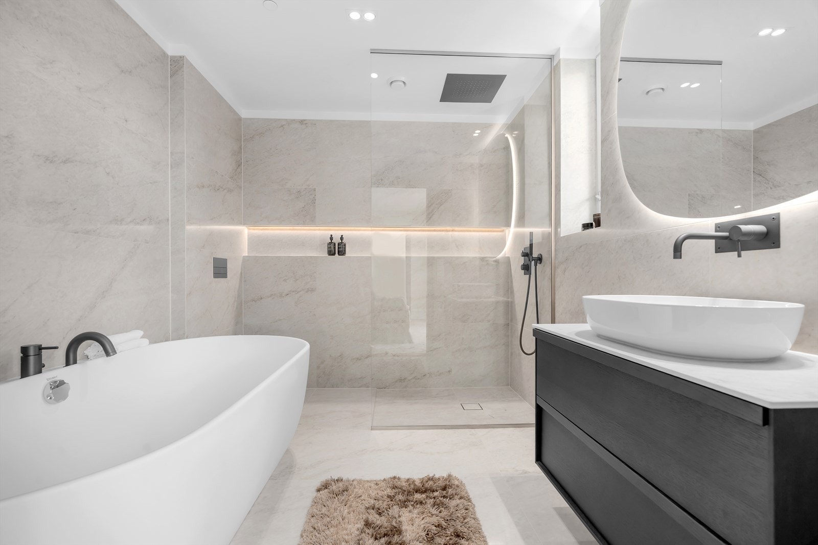 Romslig dusj med god plass og elegant belysning i hyllene. Galleribilde