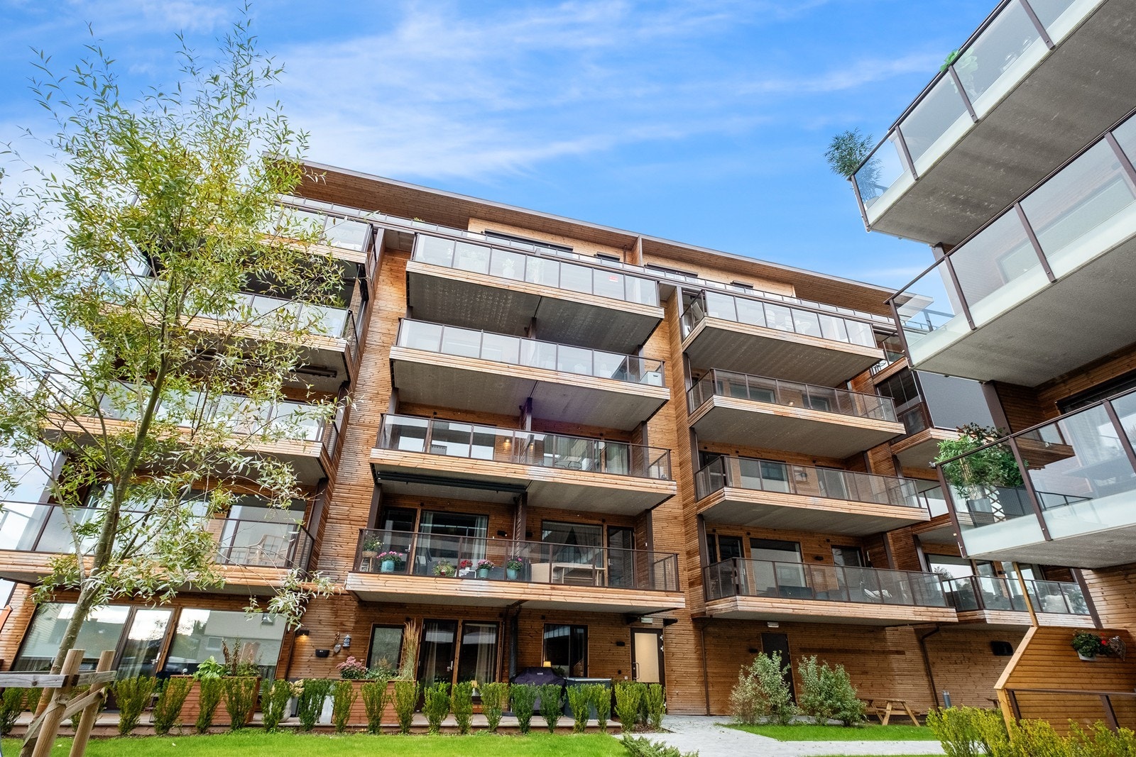 Leiligheten og balkongen vender ut mot en pent opparbeidet bakgård Galleribilde