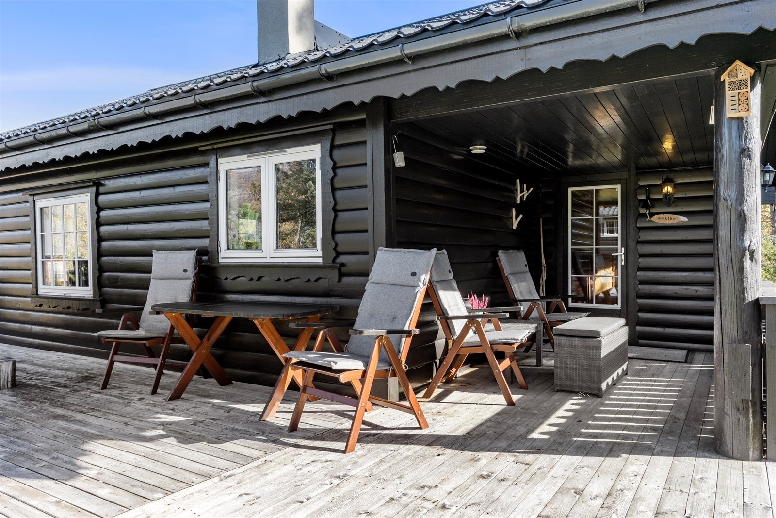 Uteområdet inkluderer også romslig terrasse som omkranser hytta, perfekt for grilling, avslapning og hygge. Del av terrasse er overbygget, så her kan en sitte ute på de mindre fine dagene og. Galleribilde