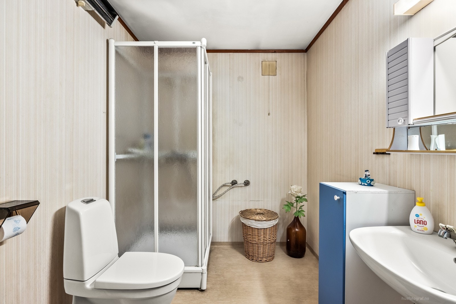 Bad/vaskerom med vinylbelegg på gulvet og tapet på veggene. Galleribilde