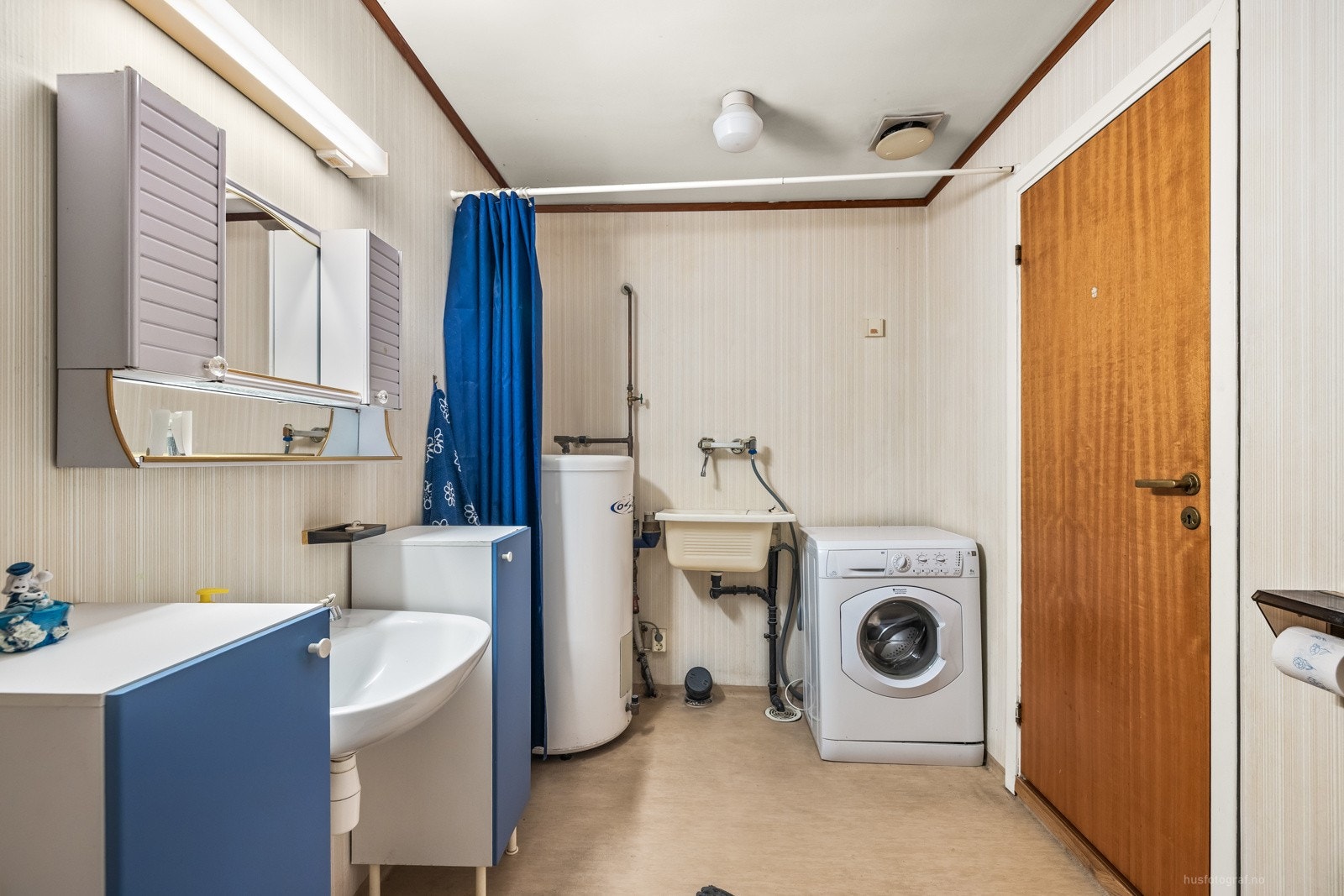 Opplegg for vaskemaskin bak forheng. Varmtvannsberederen er plassert i hjørnet. Galleribilde