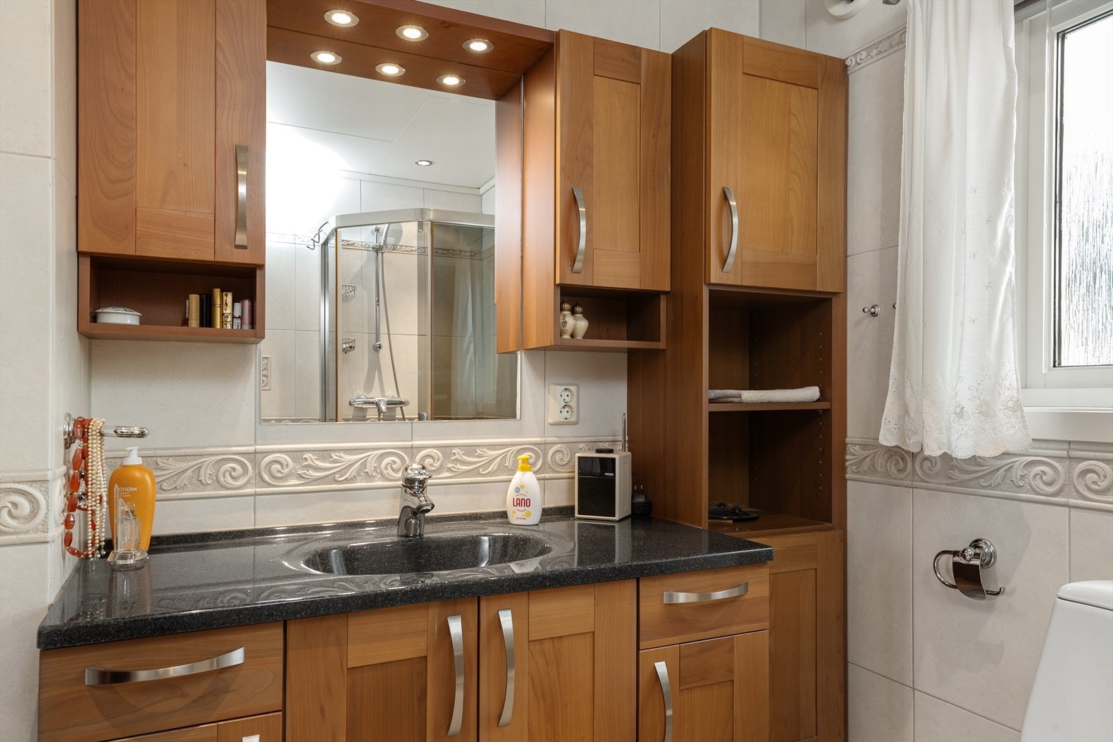 Inneholder baderomsinnredning, høyskap, toalett og dusjhjørne. Galleribilde