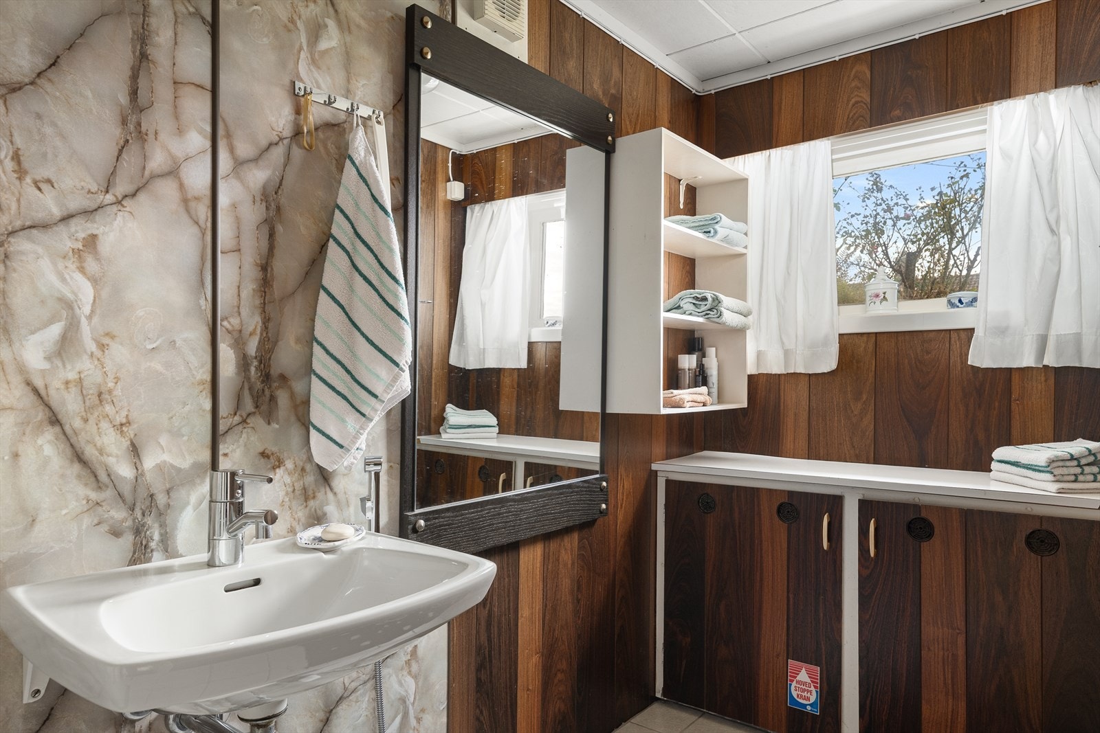 Badet har fliser på gulv, samt panelplater og baderomsplater på vegger. Galleribilde