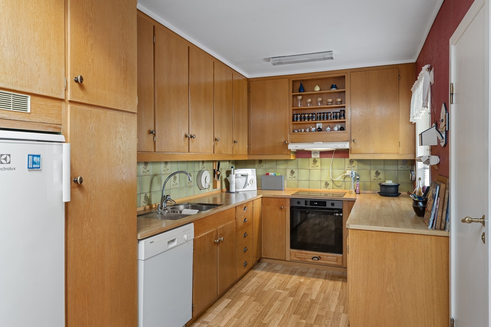 Kjøkkeninnredning med slette fronter av tre og laminert benkeplate. Galleribilde