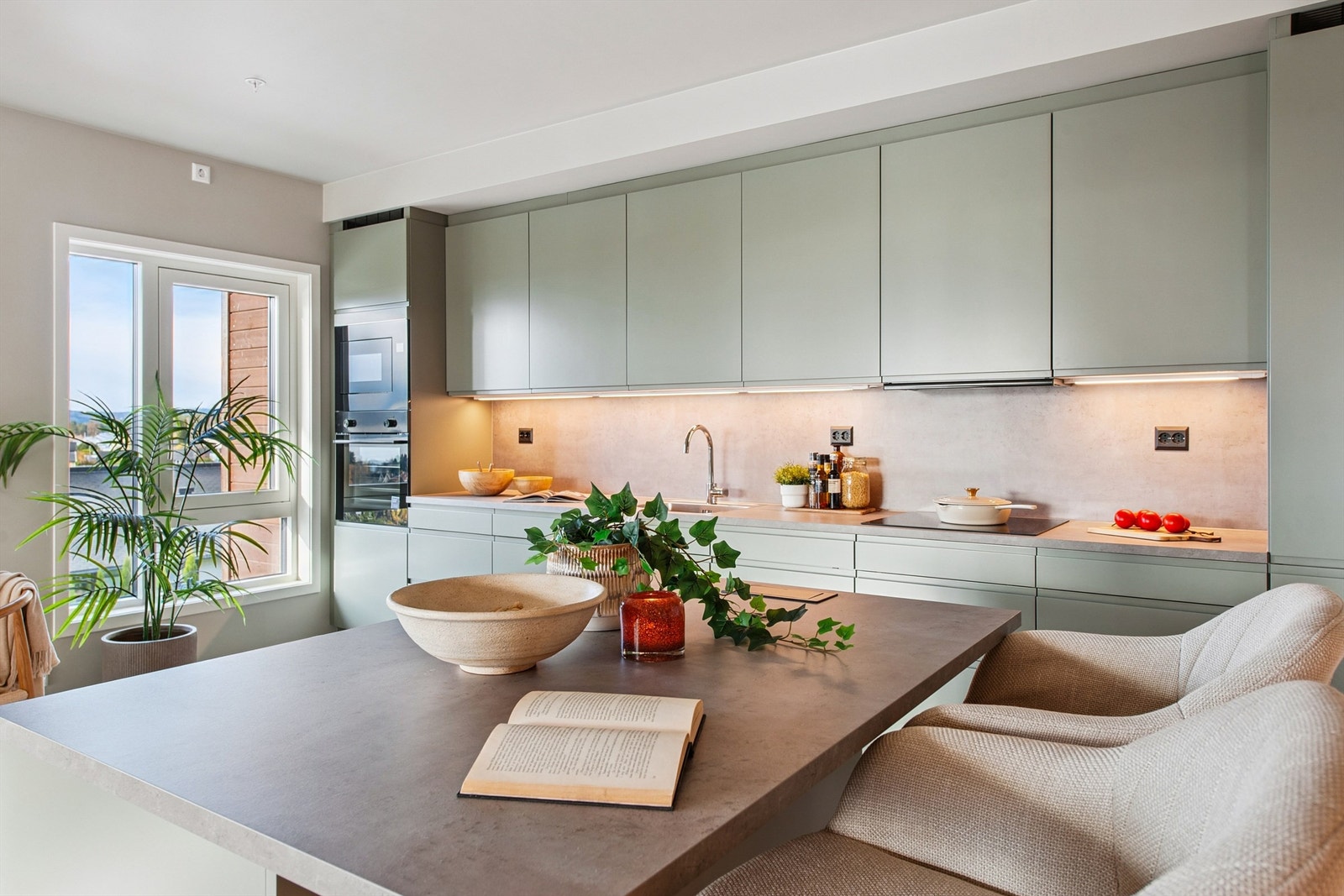 Rikelig med skap- og benkeplass gjør kjøkkenet både funksjonelt og stilrent. Høyskap med ovn og micro. Galleribilde