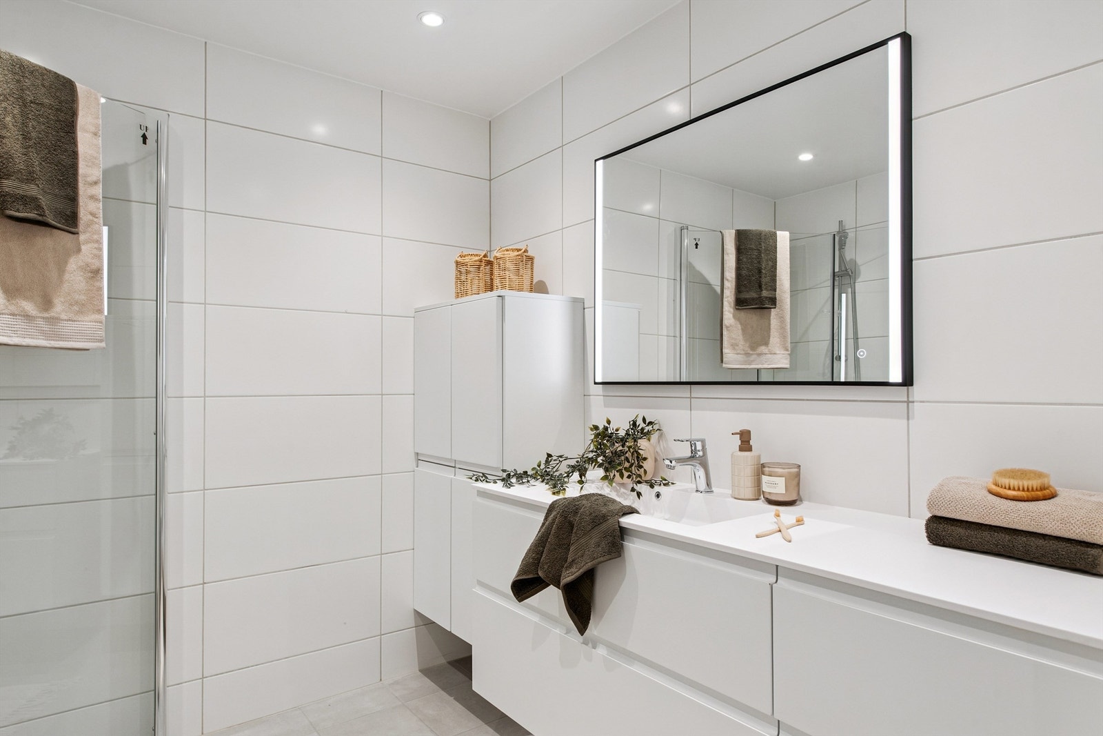 Hovedbadet er helfliset med en bred servantinnredning som gir rikelig med oppbevaringsplass. Speil med integrert lys. Galleribilde