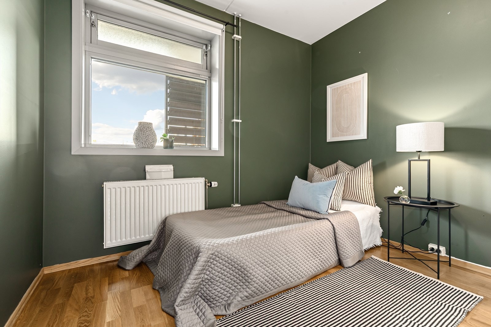 Et romslig soverom med plass til dobbeltseng og nattbord Galleribilde