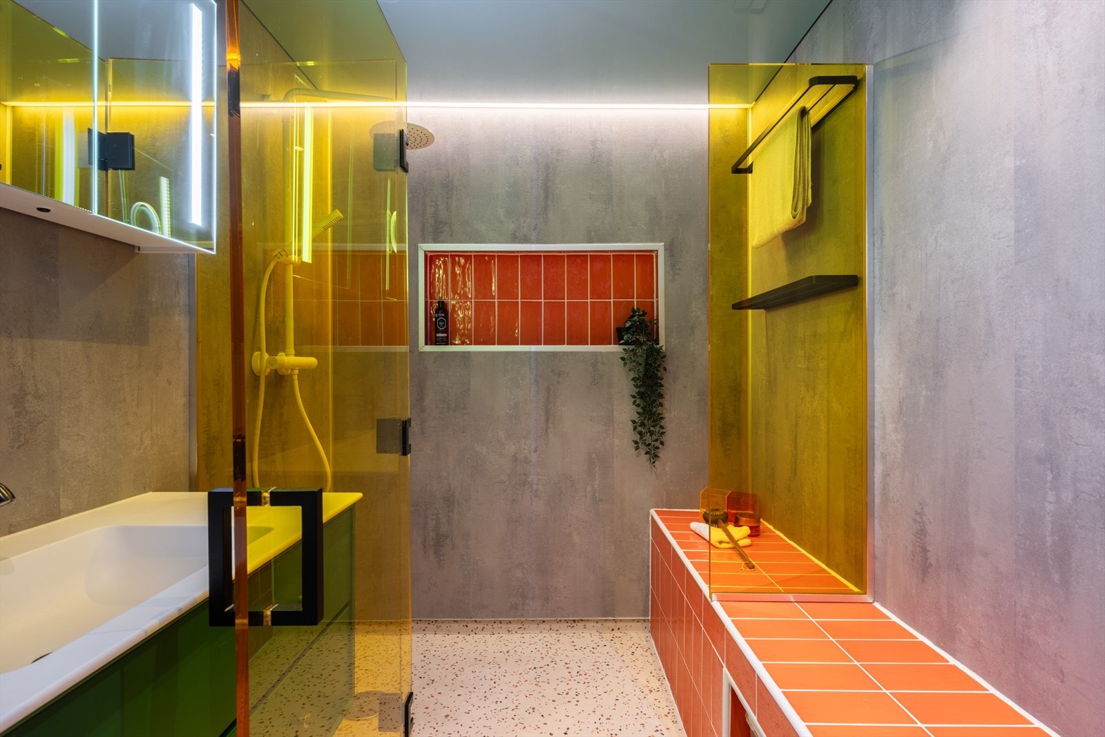 Videre er badet innredet med servant med underskap, vegghengt toalett og dusjhjørne med svingbar glassvegg. Galleribilde