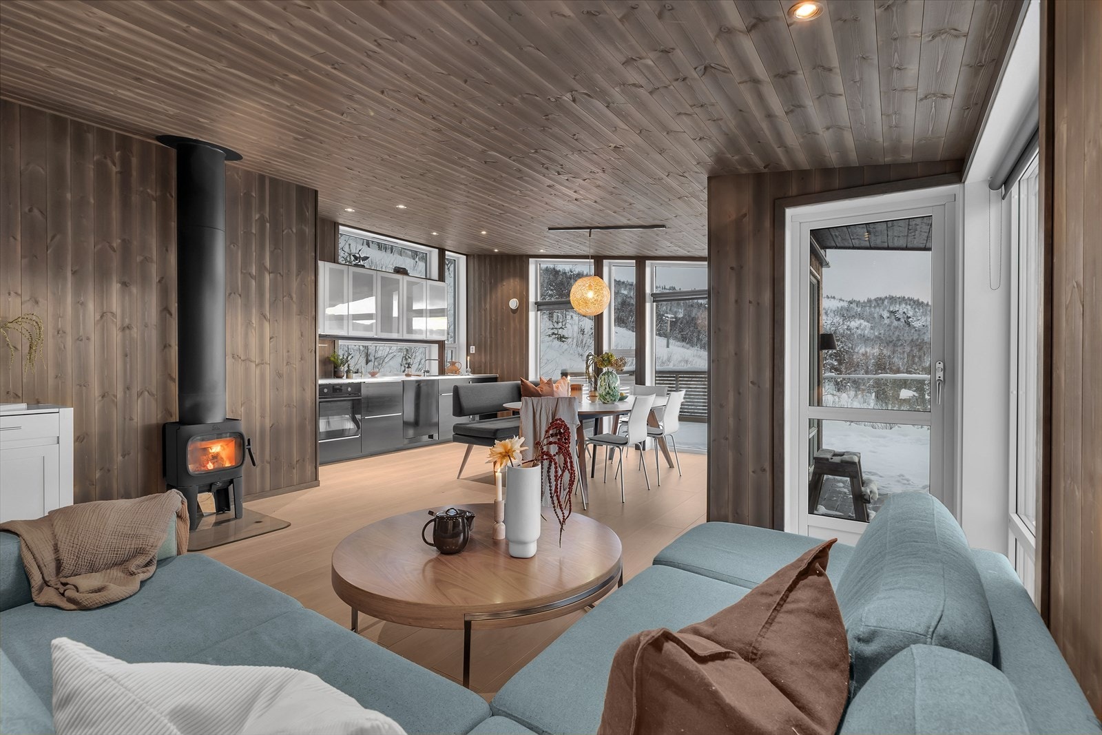 Stue og kjøkken i åpen løsning med ildsted og varmekabler i gulv Galleribilde