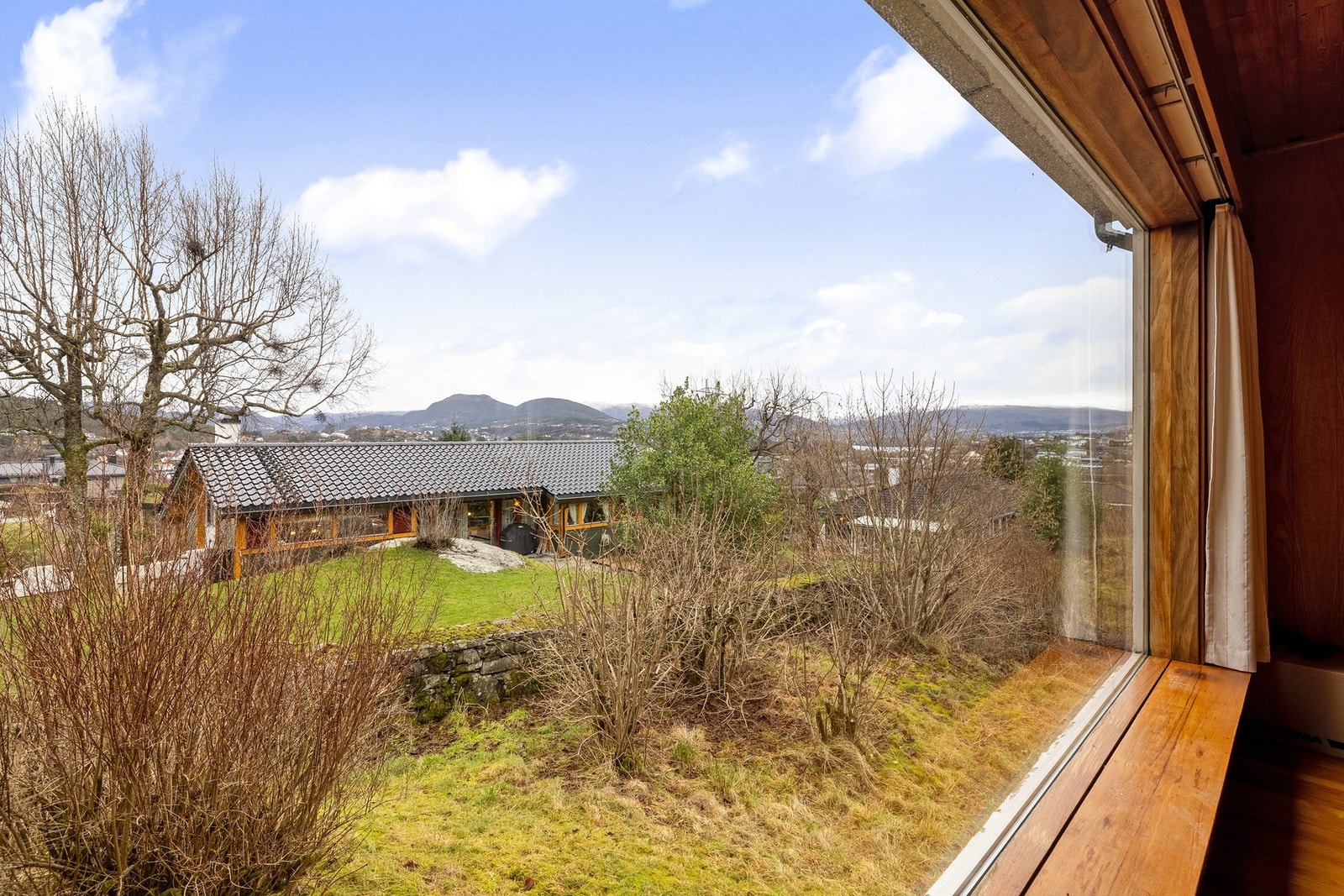 Det store vinduet i stuen slipper inn godt med naturlig lys og en koselig utsikt over området og Knappenfjellet. Galleribilde