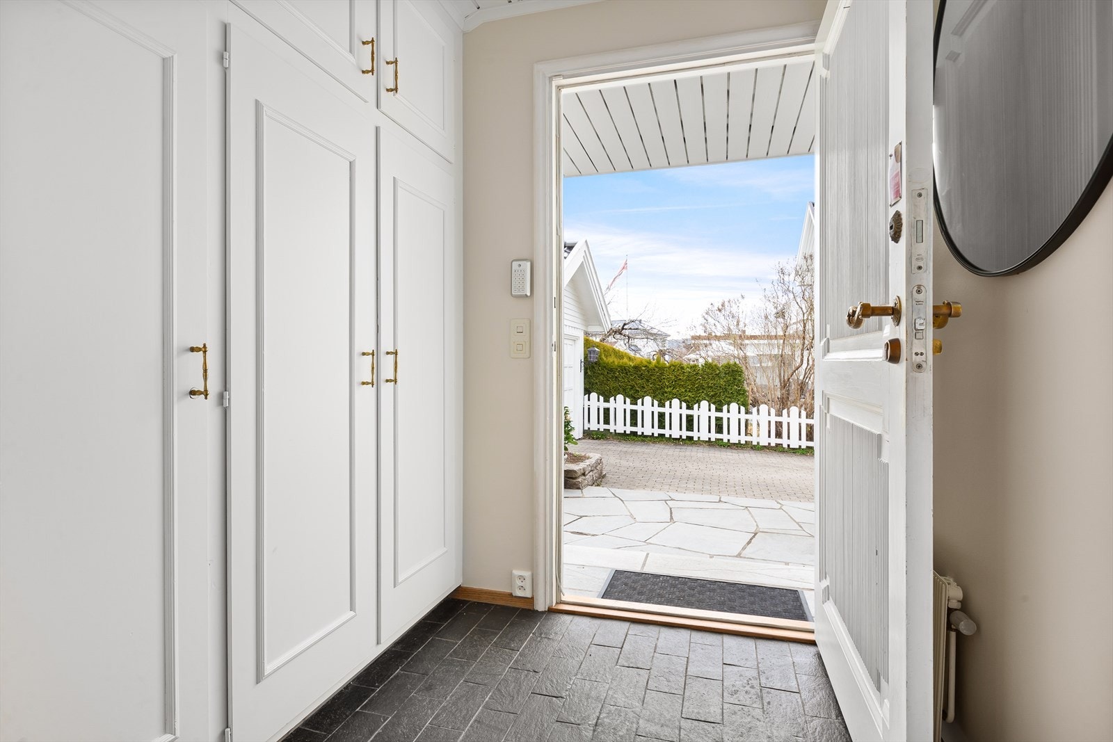 Inn døren kommer man inn til en flislagt entré med plassbygget garderobeløsning Galleribilde
