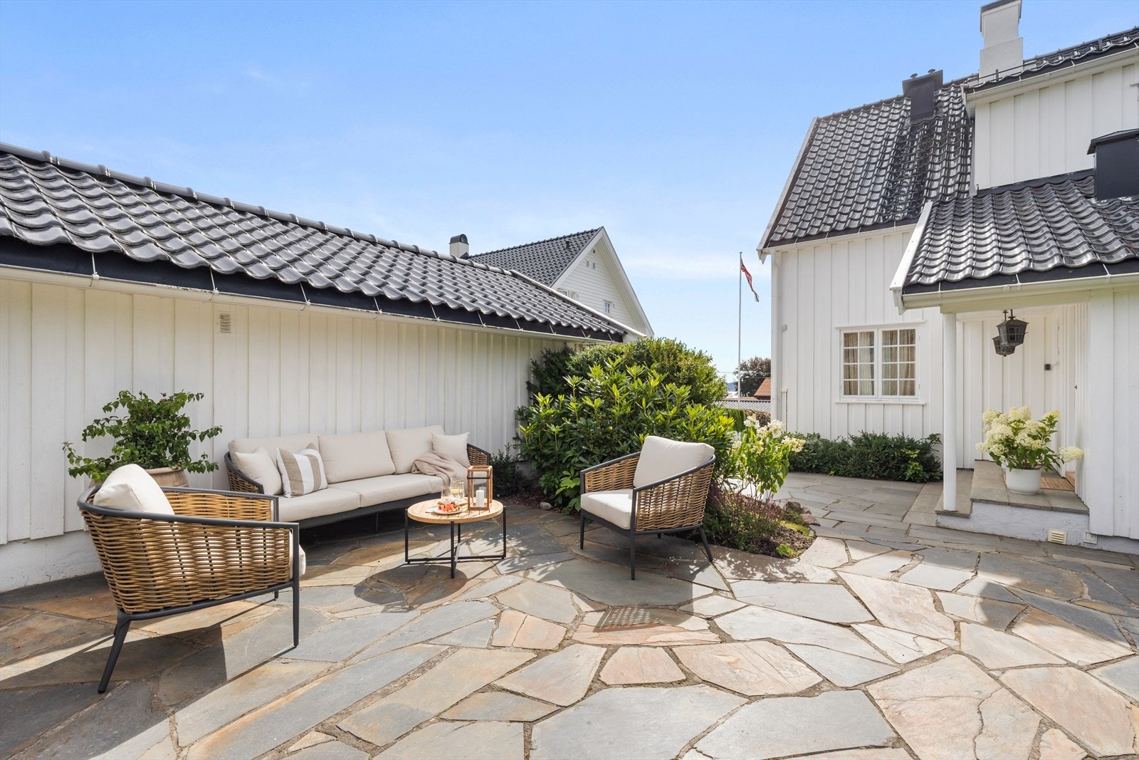 Steinbelagt uteplass ved inngangspartiet med gode møbleringsmuligheter Galleribilde