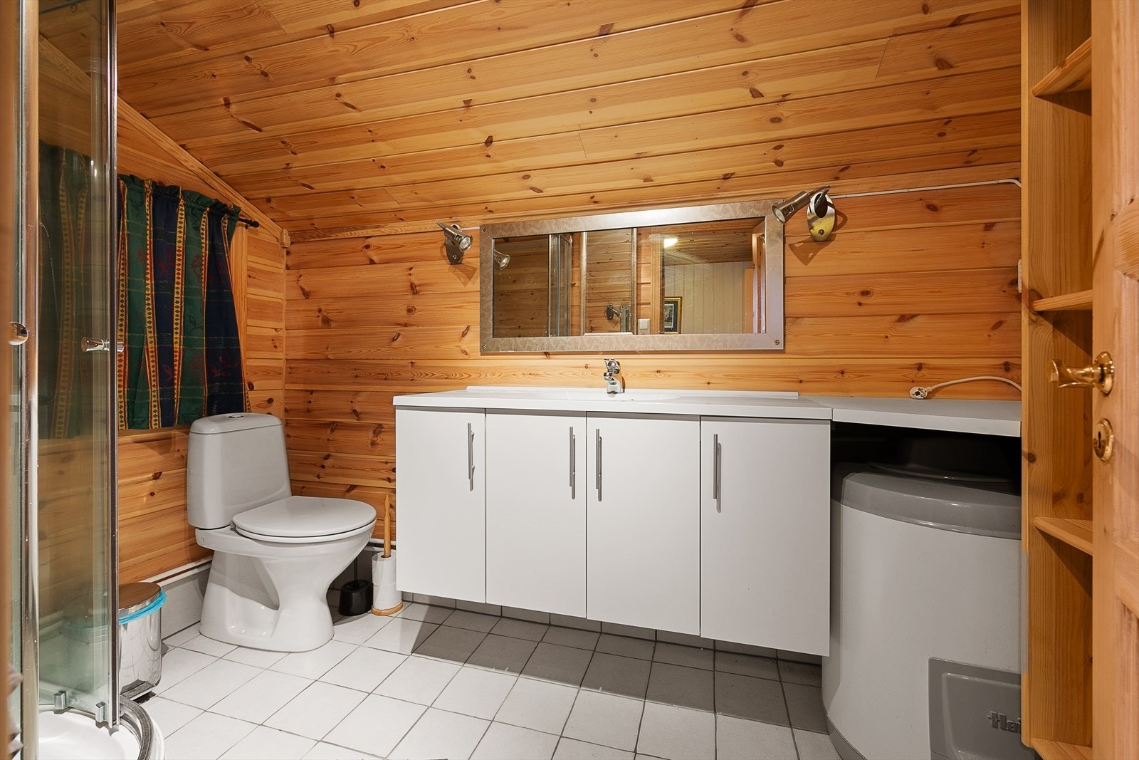 Badet har dusjkabinett, wc og servant med skap Galleribilde