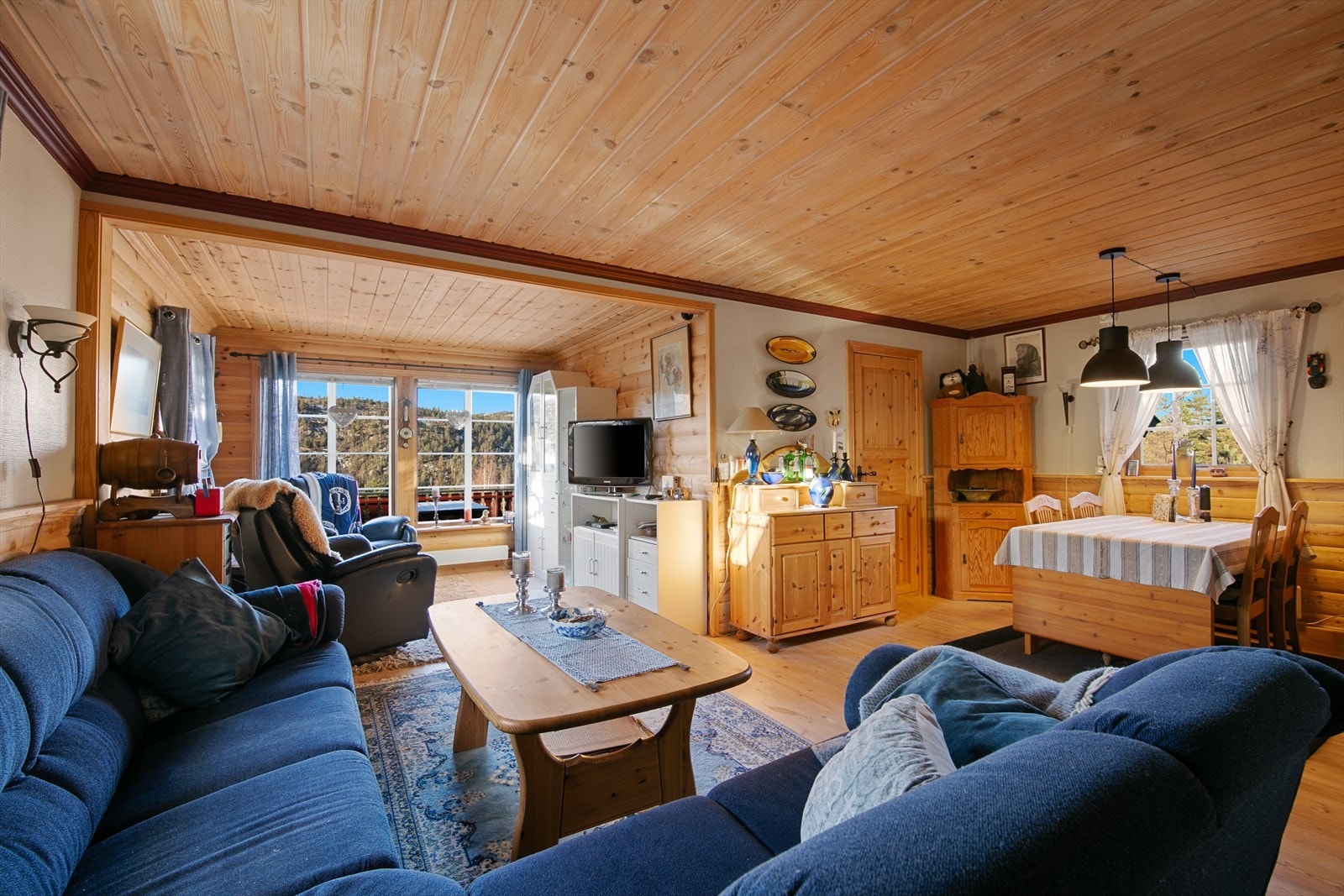 Lys og romslig stue med store vinduer som slipper inn rikelig med naturlig lys Galleribilde